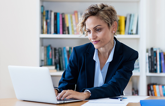 a woman in a suit working on a laptop