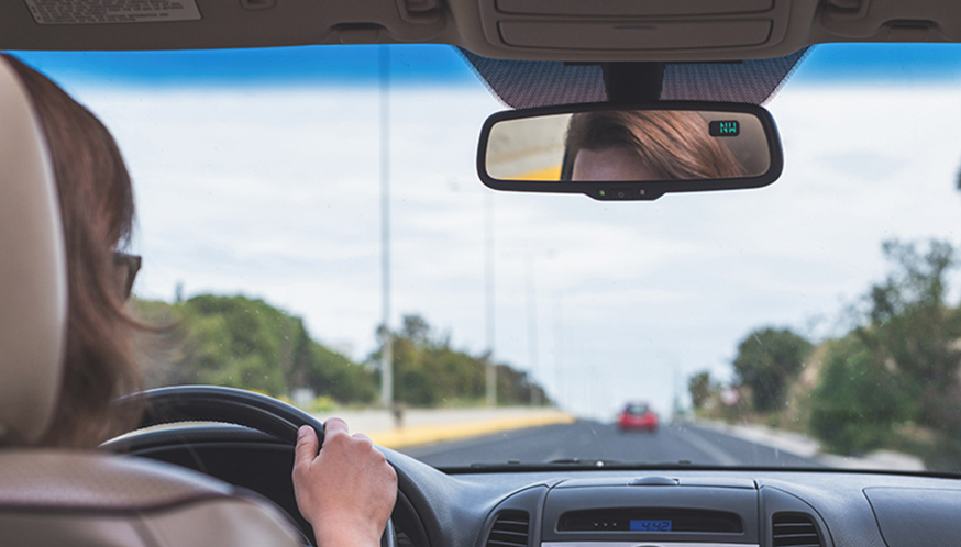 a rear view mirror of a person driving a car