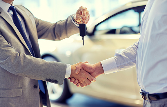 a man shaking hands with a car key