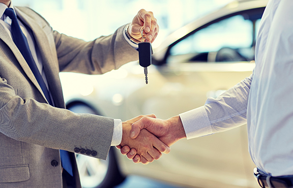 a man shaking hands with a car key