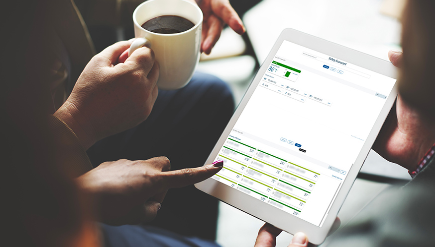 a person holding a cup of coffee and a tablet