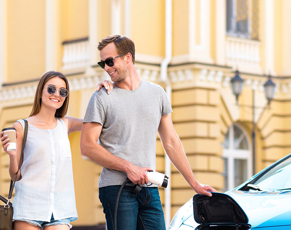a man and woman standing next to a car