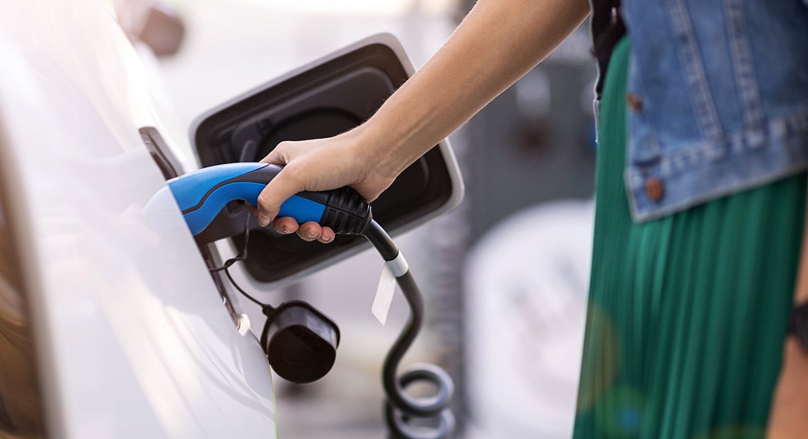 A person charging an electric vehicle