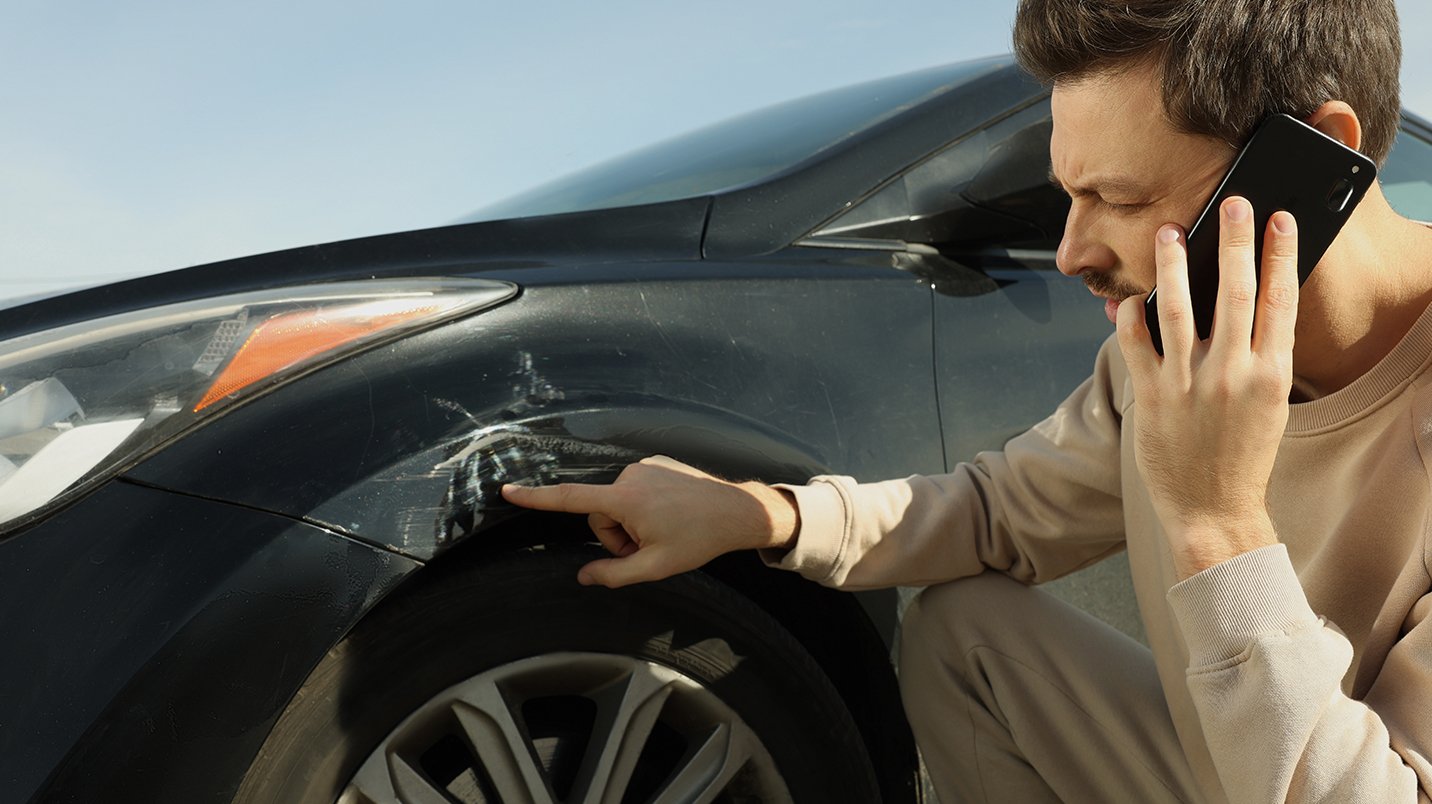 a man pointing at a damaged tire