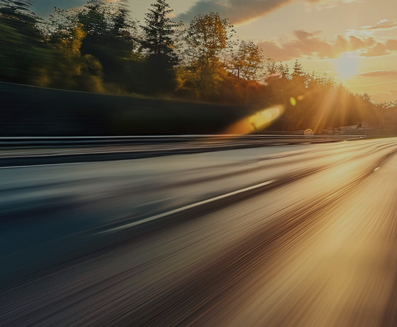 a blurry road with trees and sun