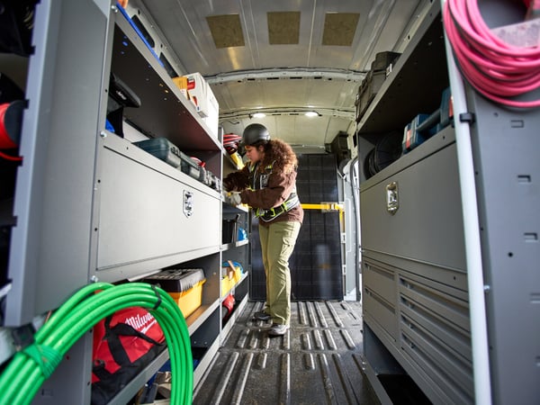 a woman in a helmet looking at a tool box
