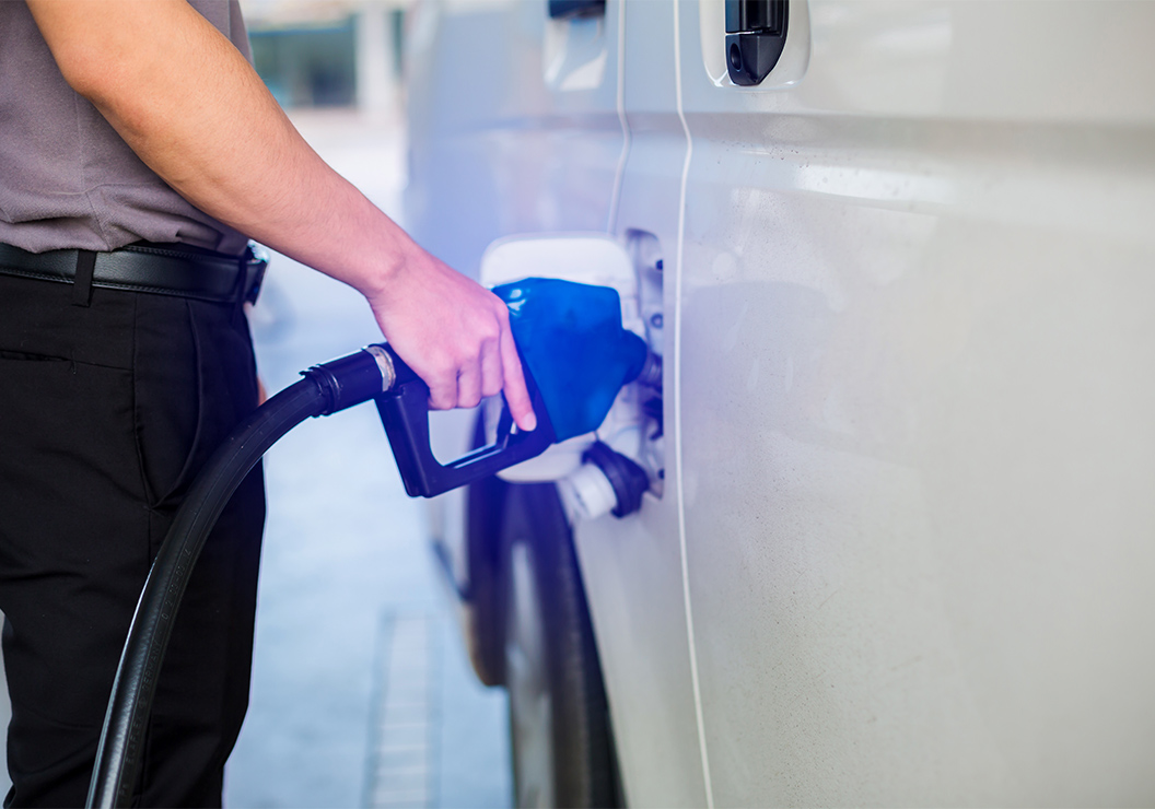 a person filling a car with a gas pump