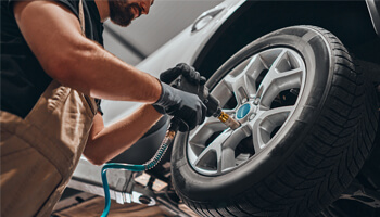 A technician working on a vehicle's wheel