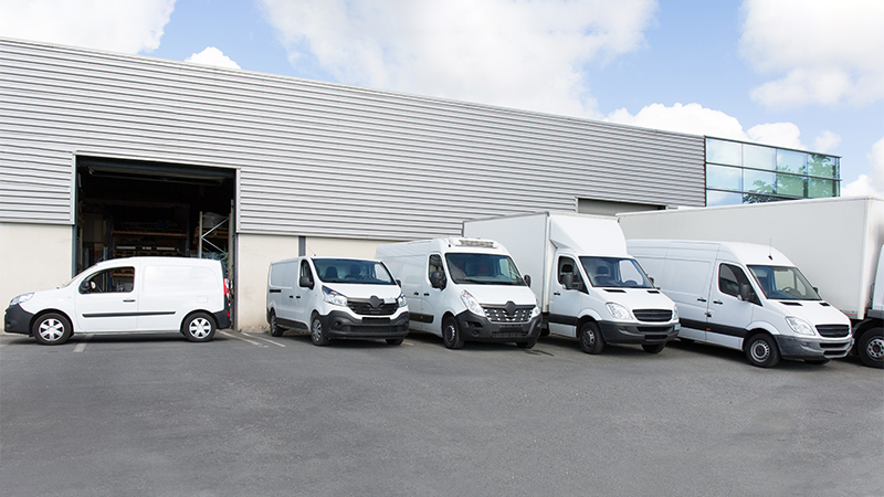 a row of white vans in front of a building
