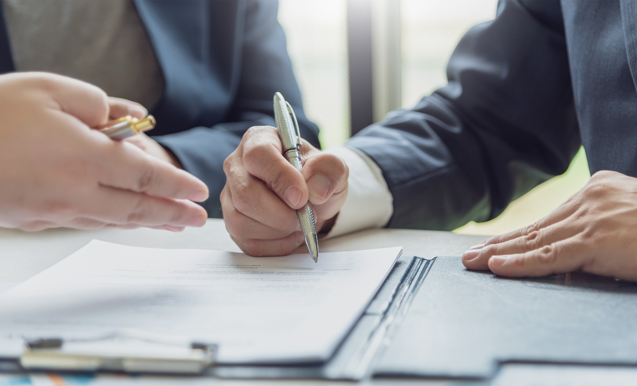 a person holding a pen over a paper