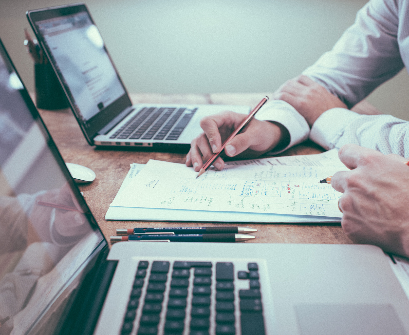 a man holding a pen and writing on a piece of paper