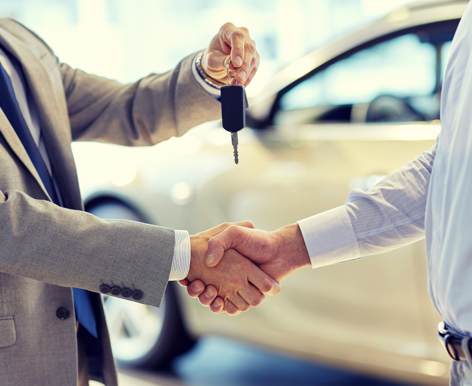 a man shaking hands with a car key