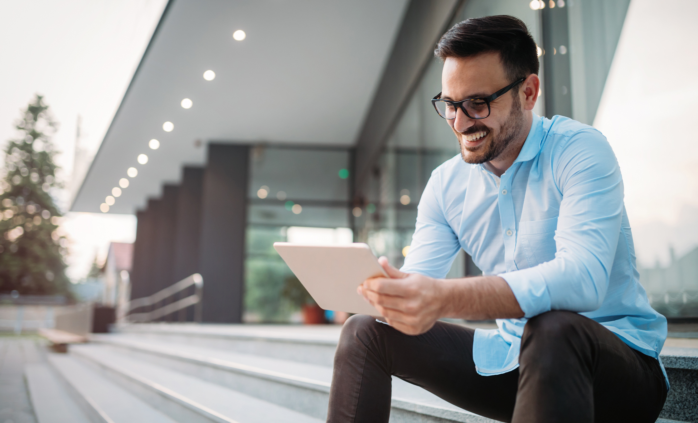 a man sitting on steps looking at a tablet