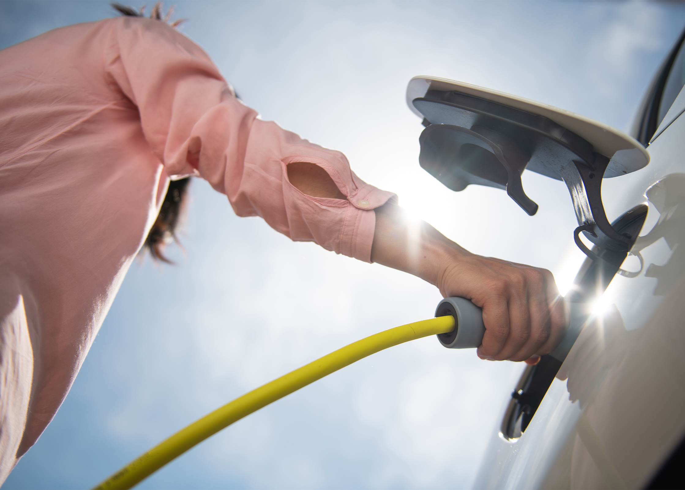 a person holding a hose to a car
