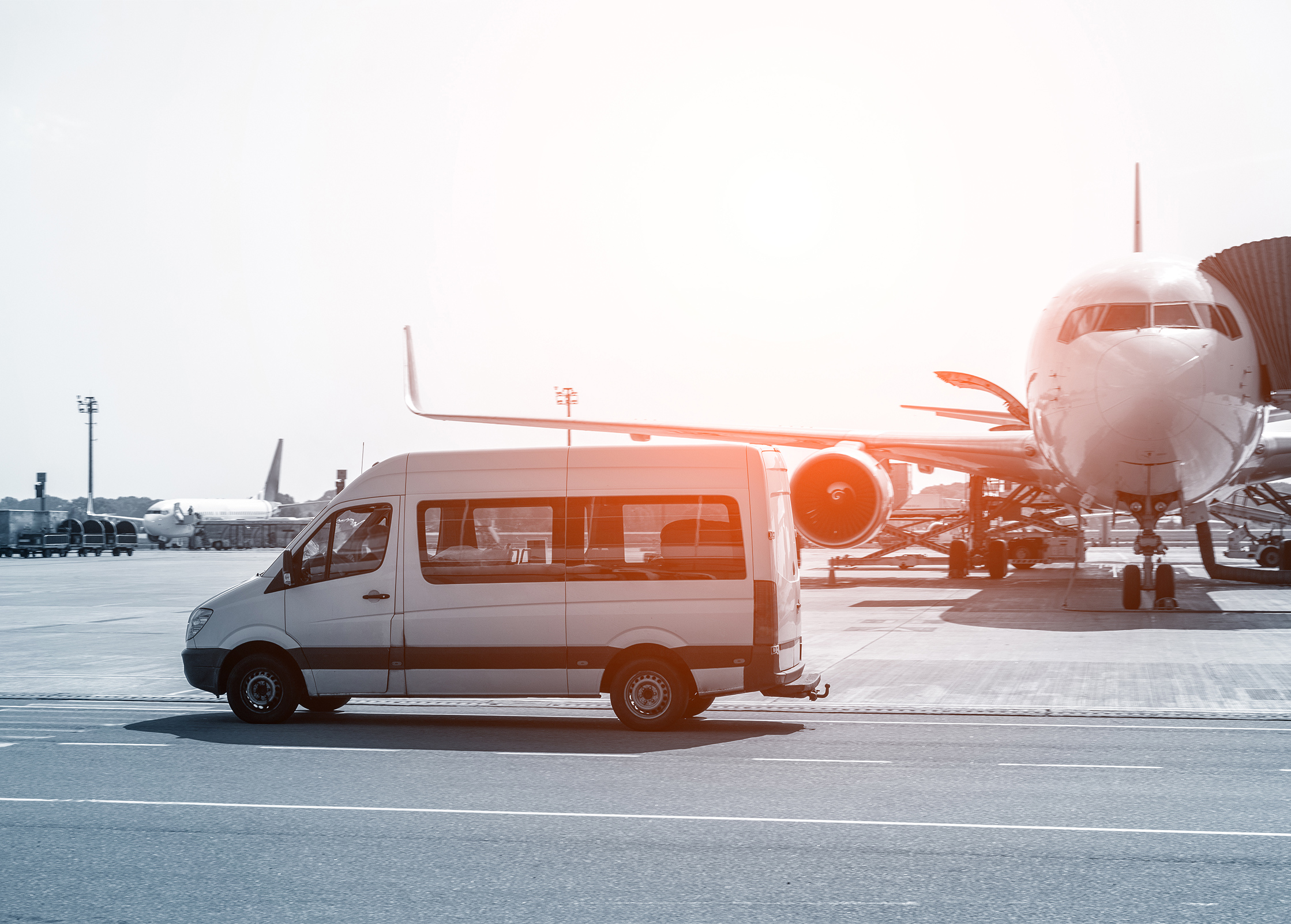 a van parked on a tarmac next to an airplane