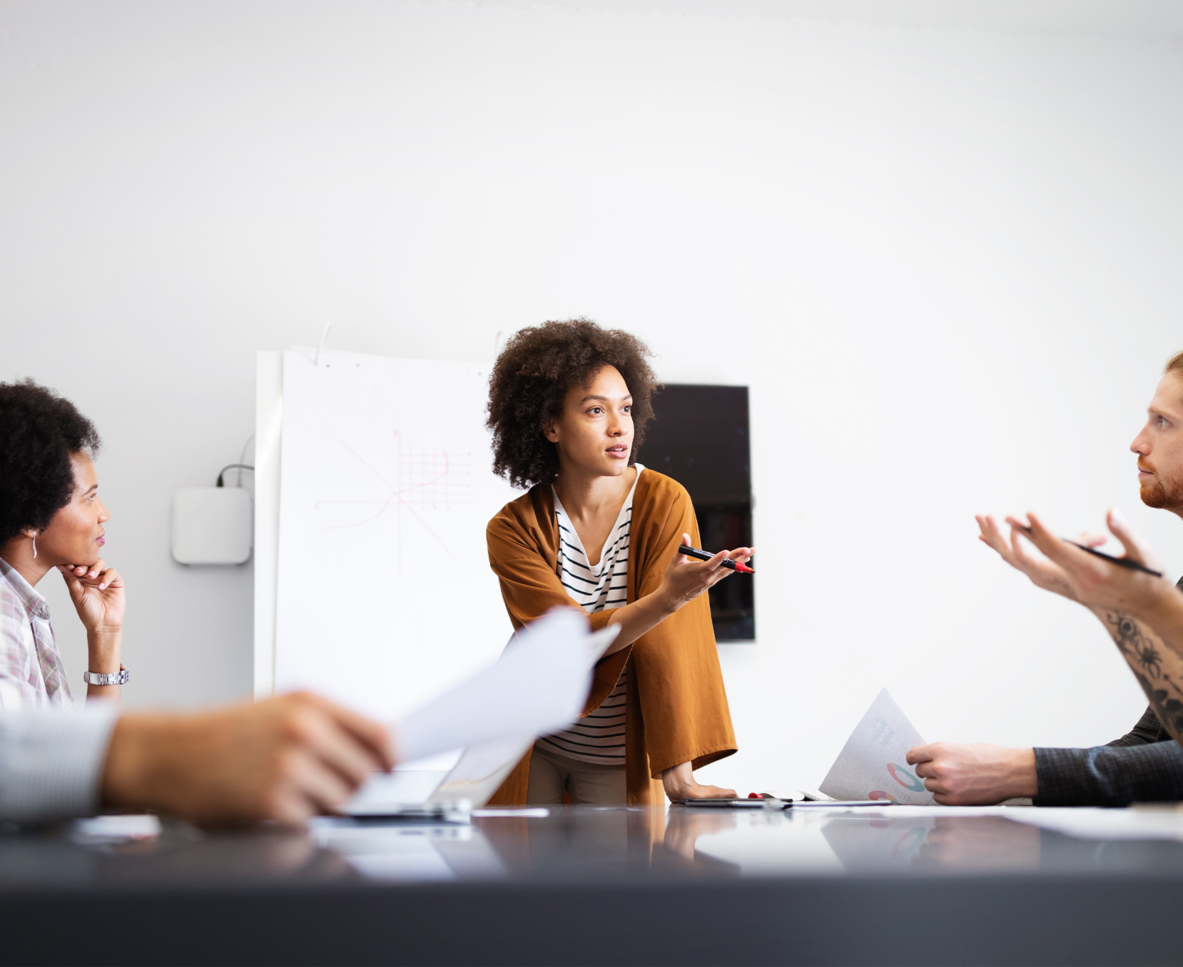a woman standing in front of a table with people in the background