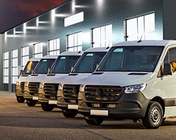 a row of white vans in front of a building