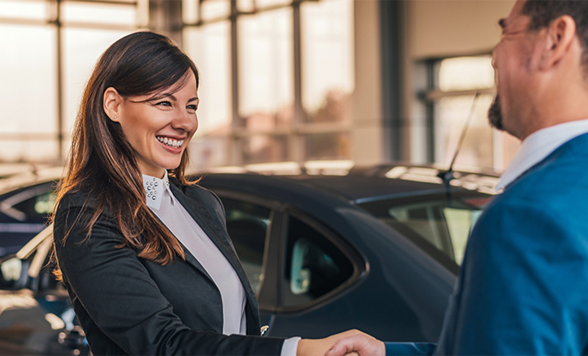 a woman shaking hands with a car