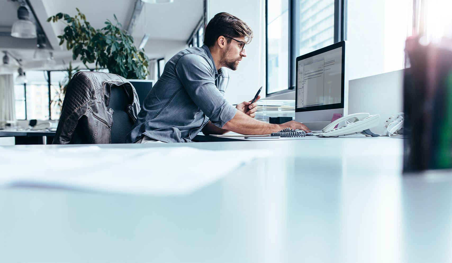 a man sitting at a desk looking at a computer