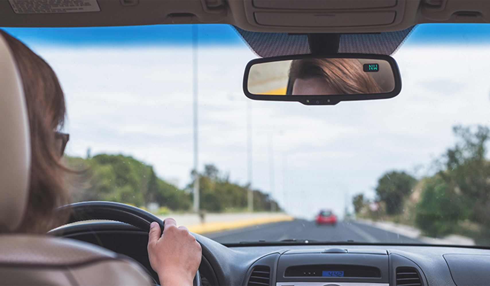 a rear view mirror of a person driving a car