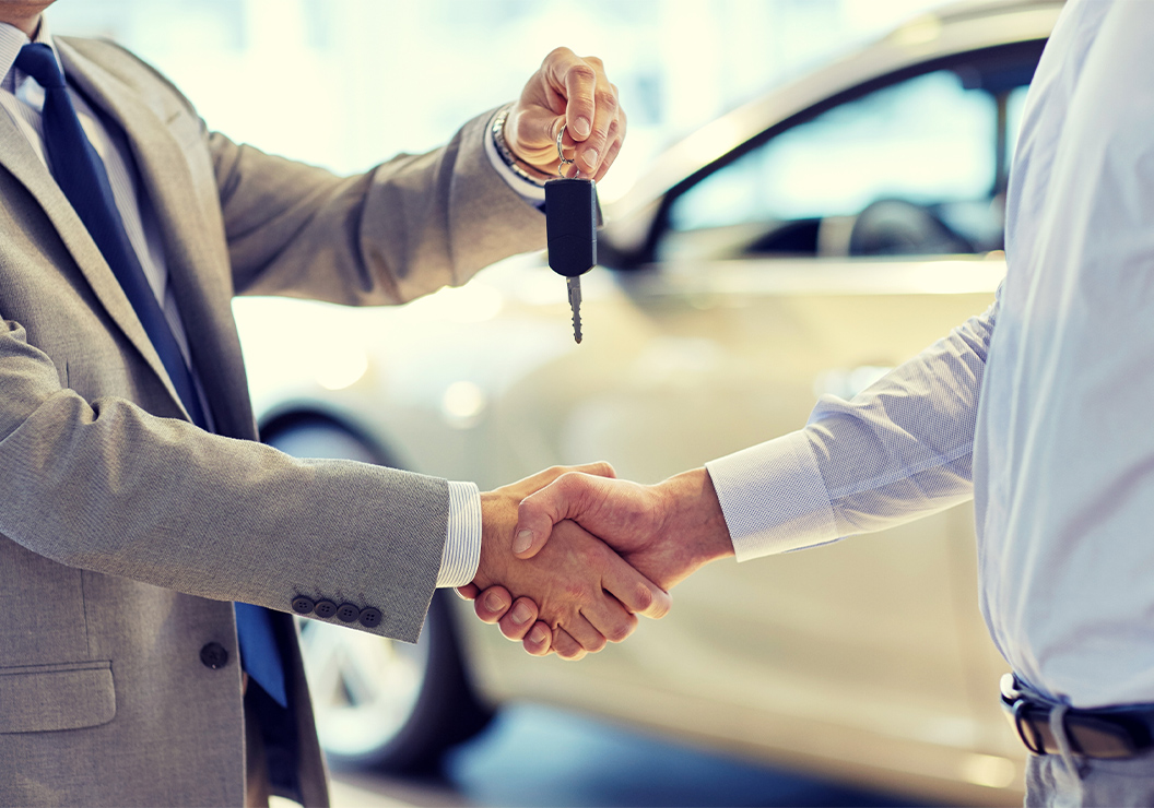 a man shaking hands with a car key