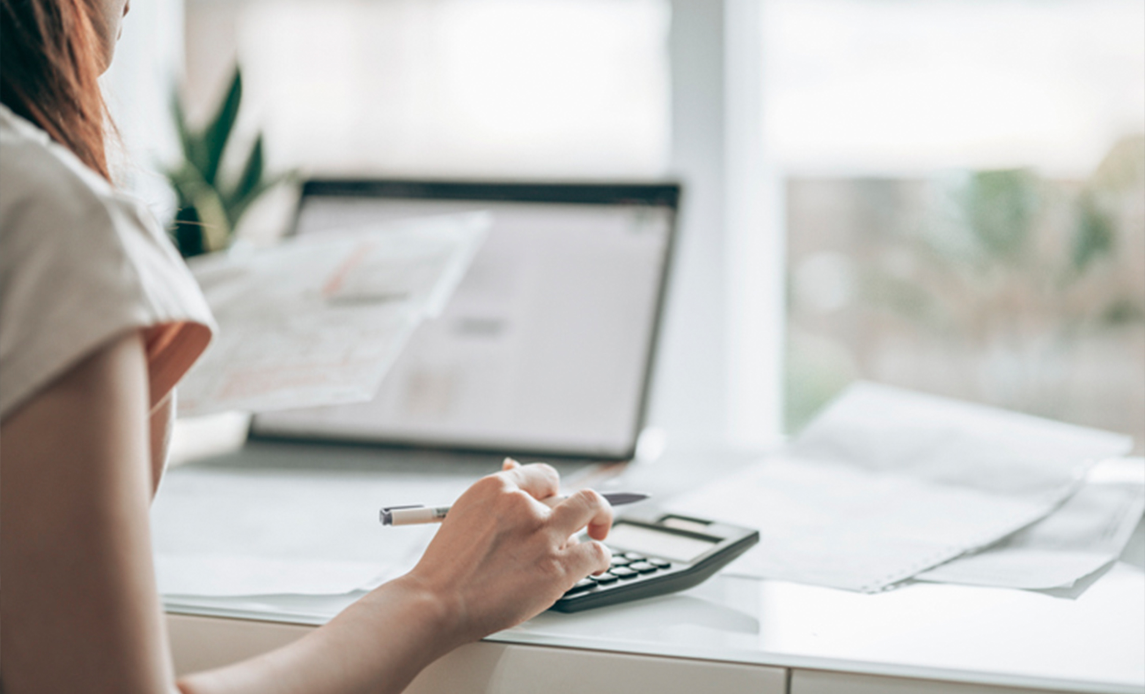 a hand holding a pen and calculator