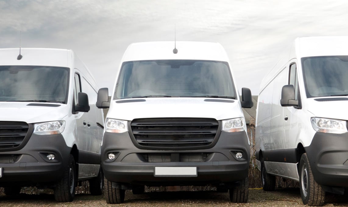 3 weisse Transporter parken in einer Reihe