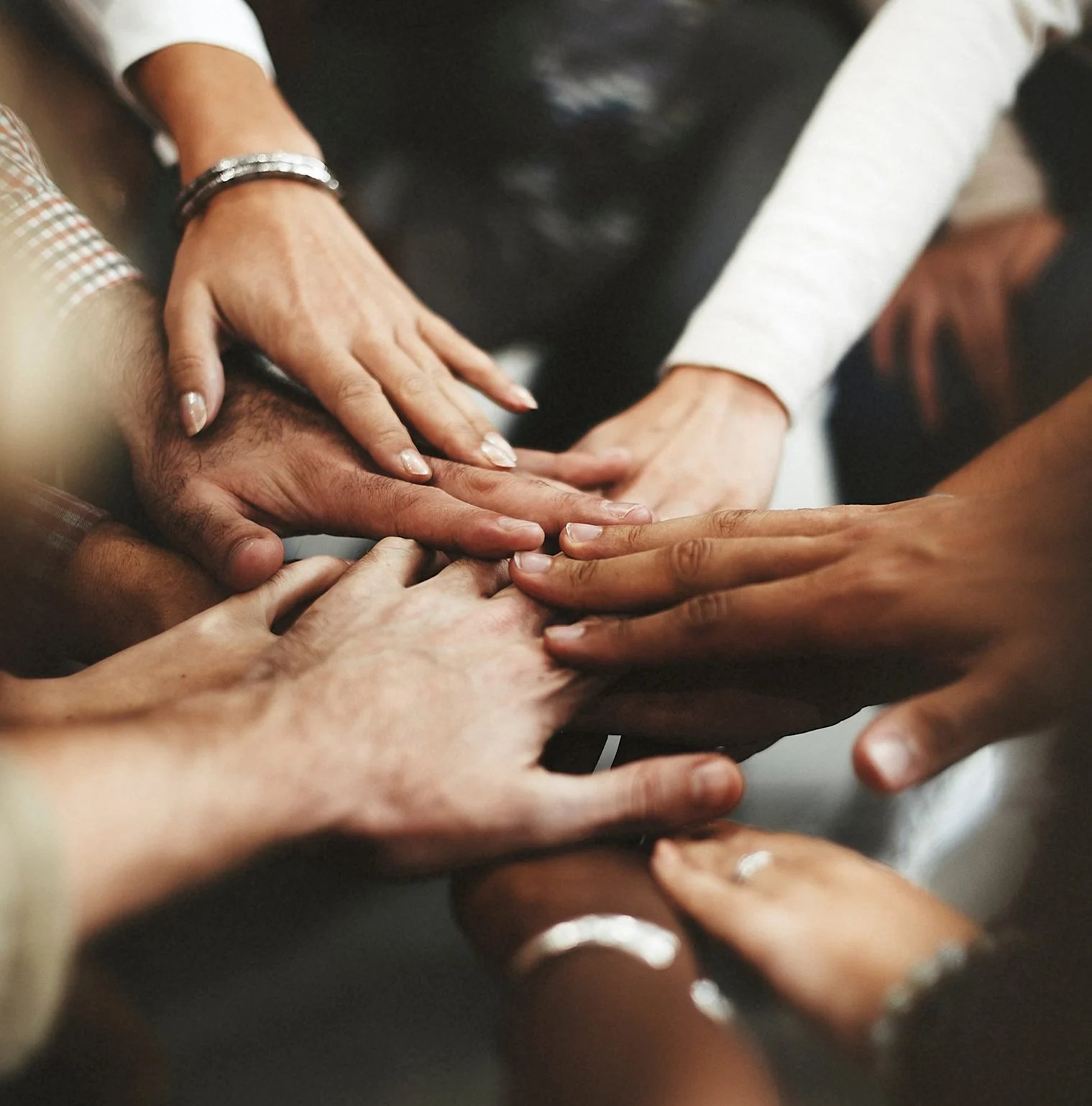 a group of people putting their hands together