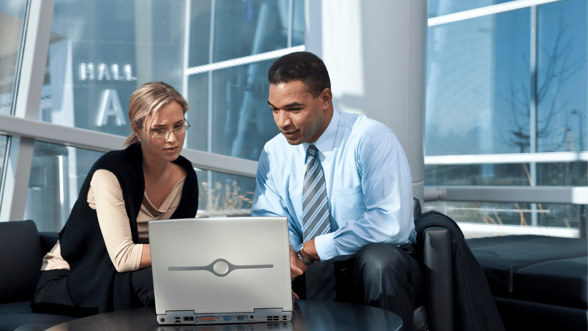 a man and woman looking at a laptop