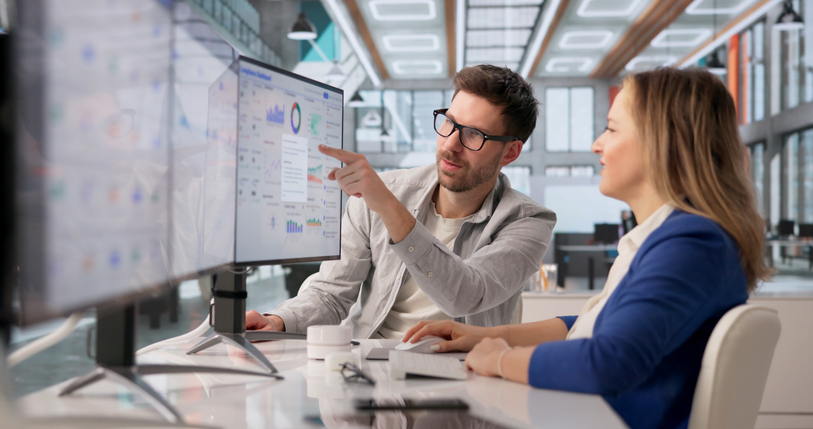 Mitarbeiter nutzen die Fuhrparksoftware Holman Insights zur Analyse von Fuhrparkdaten, Kosten, Fahrzeugstatus und Leistungskennzahlen auf einem digitalen Dashboard.