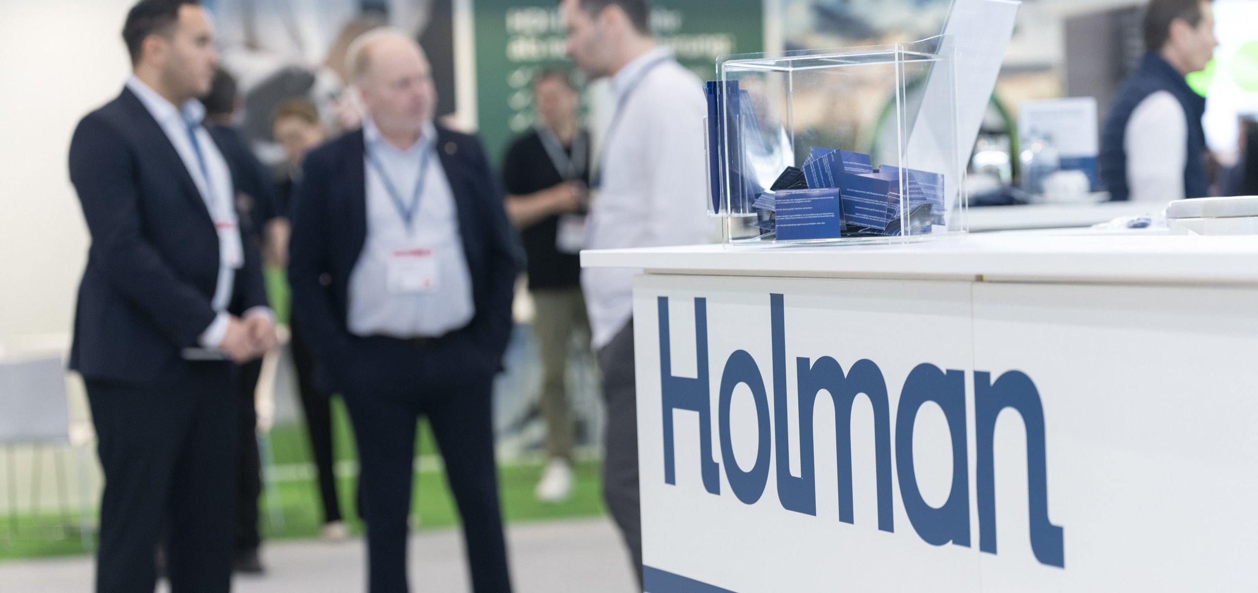 Networking am Holman Messestand während einer Fachmesse für Fuhrparkverantwortliche. Weitere Zeilen anzeigen