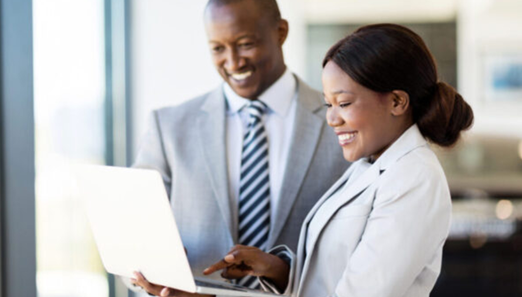 a man and woman looking at a laptop