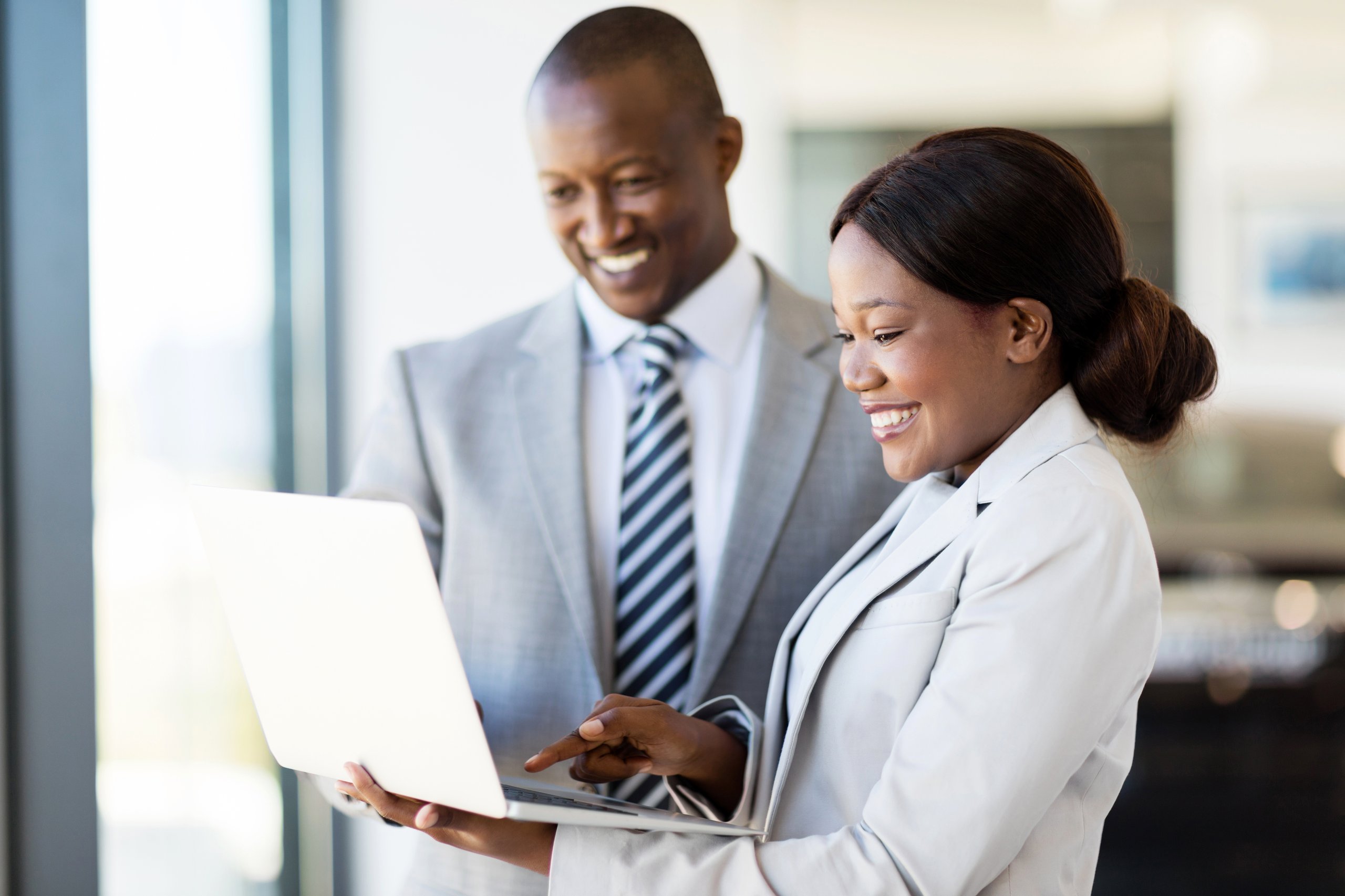 a man and woman looking at a laptop