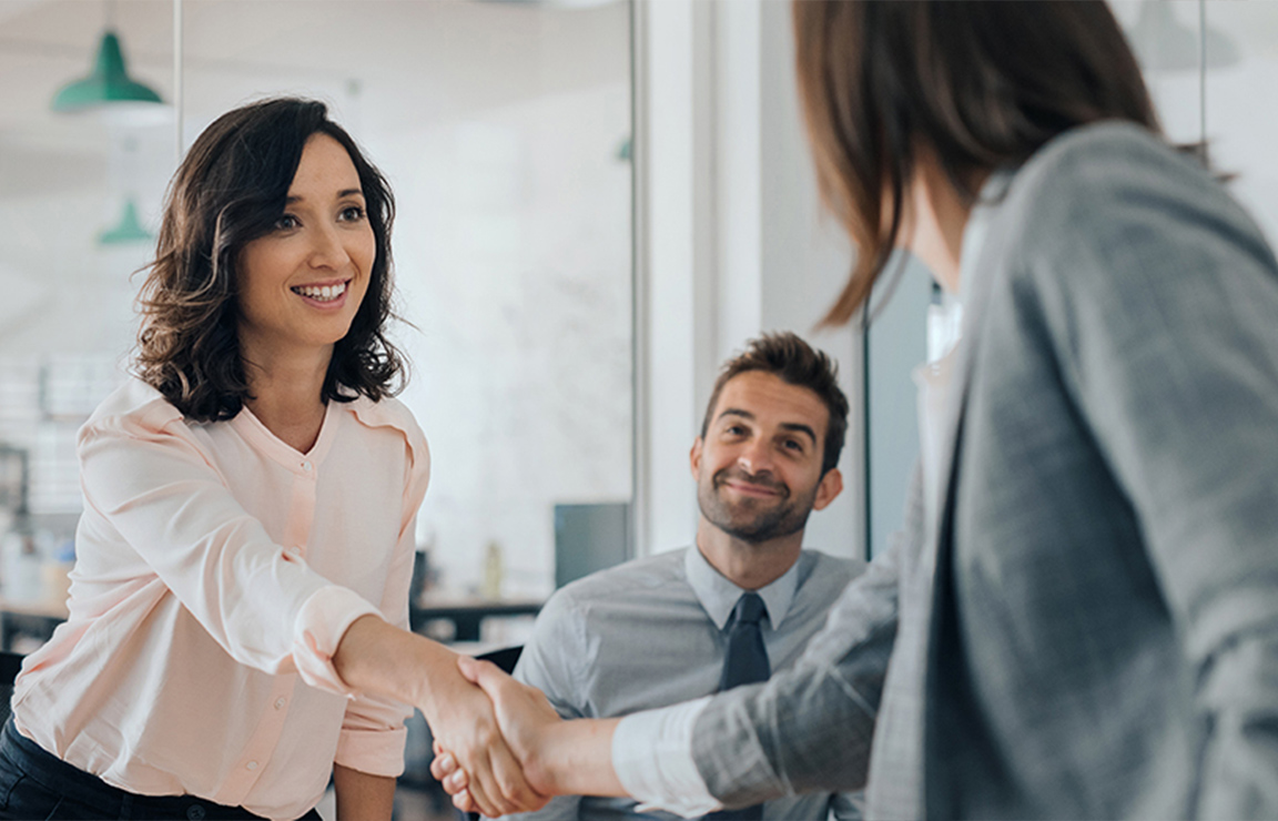 a woman shaking hands with a man in a suit