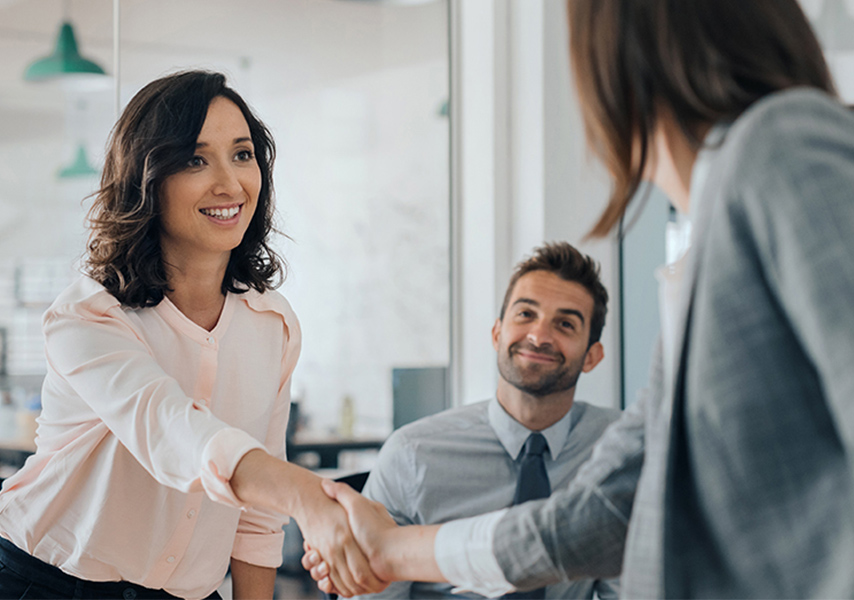 a woman shaking hands with a man in a suit