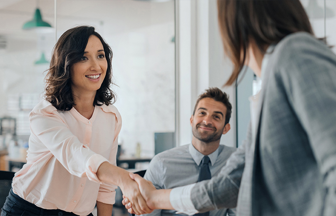a woman shaking hands with a man in a suit