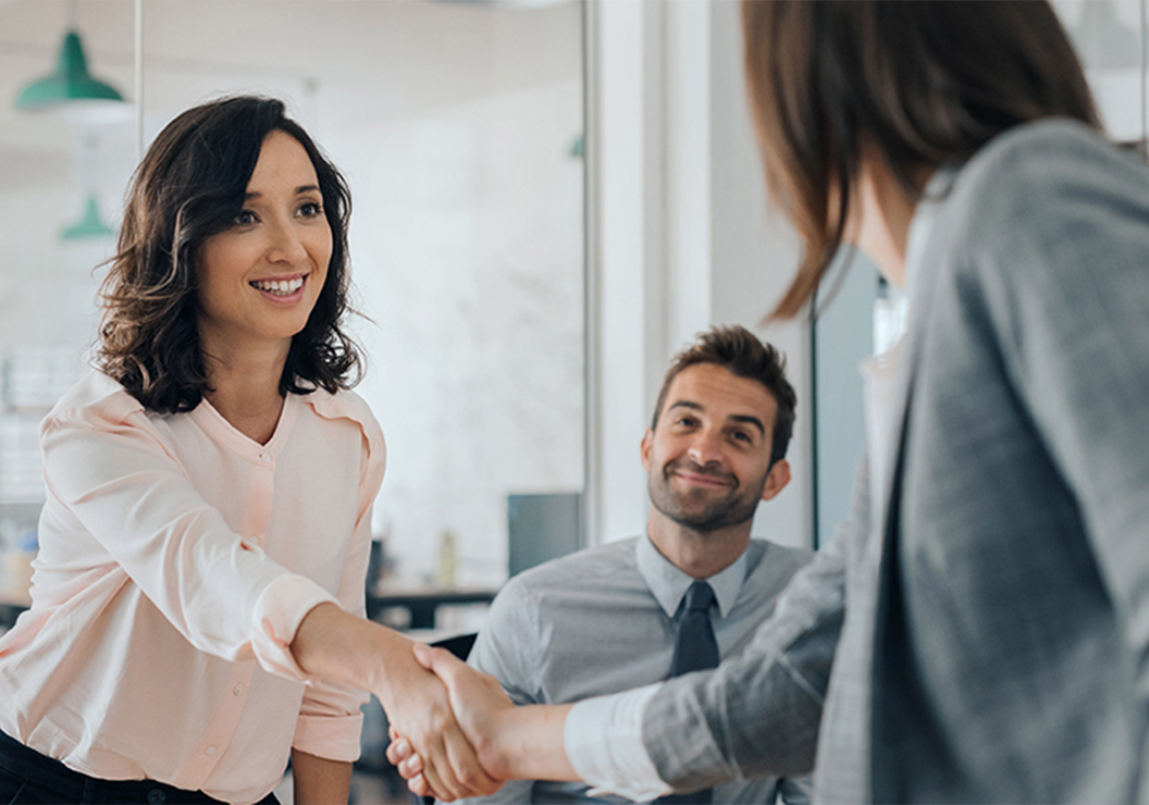 a woman shaking hands with a man in a suit
