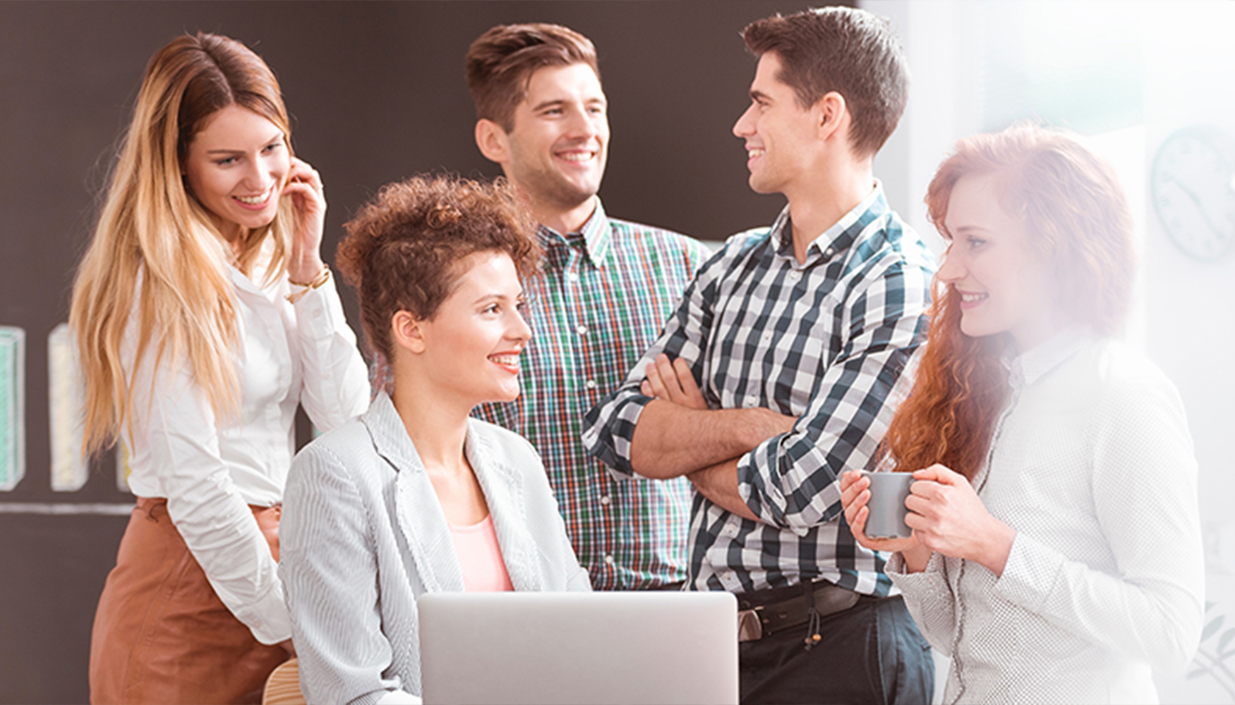 a group of people around a laptop