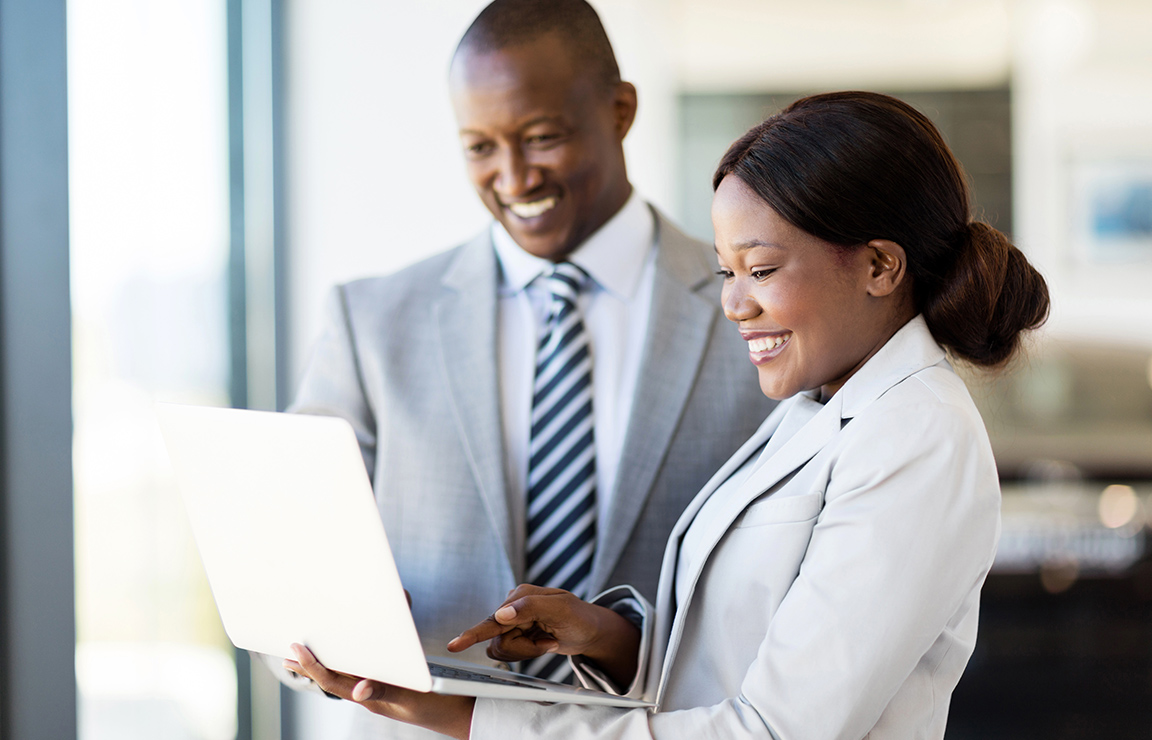 a man and woman looking at a laptop