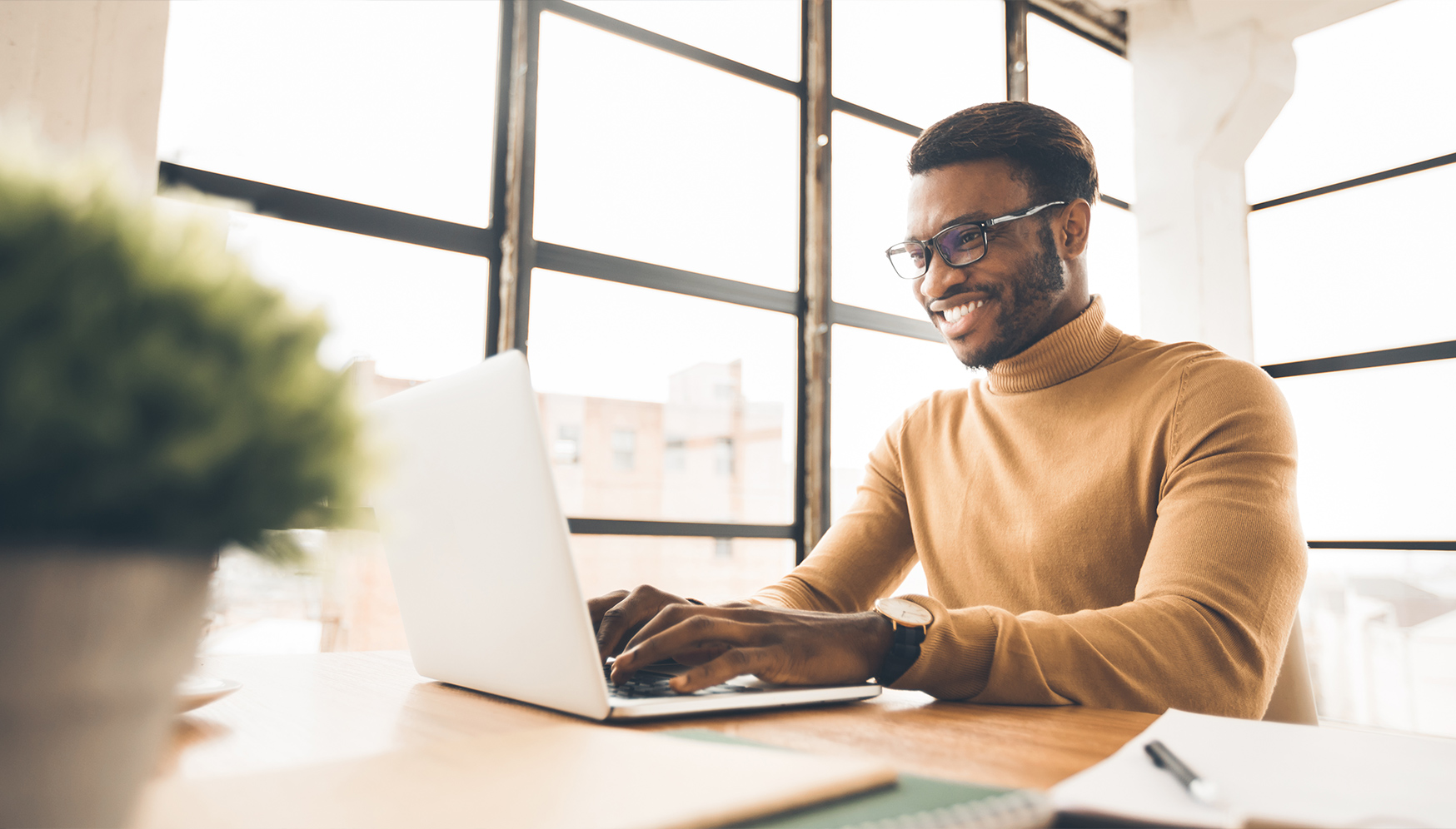 a man sitting at a desk using a laptop