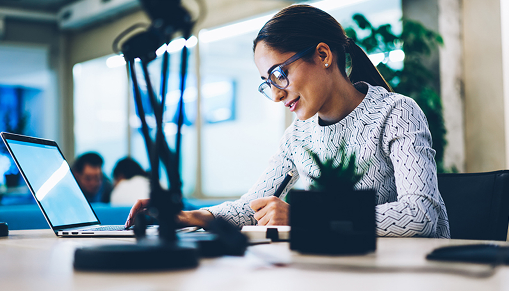 a woman sitting at a desk using a laptop