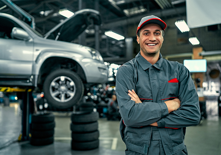a man in a uniform standing in front of a car