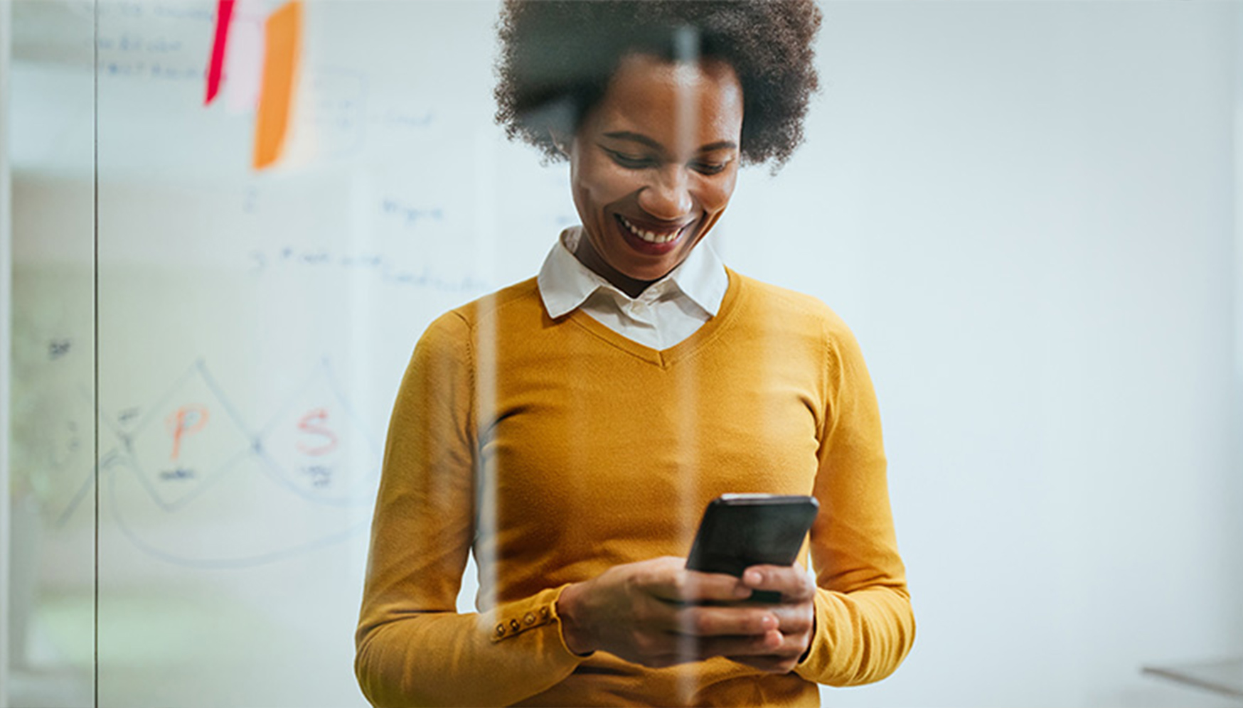 a woman smiling while looking at a phone