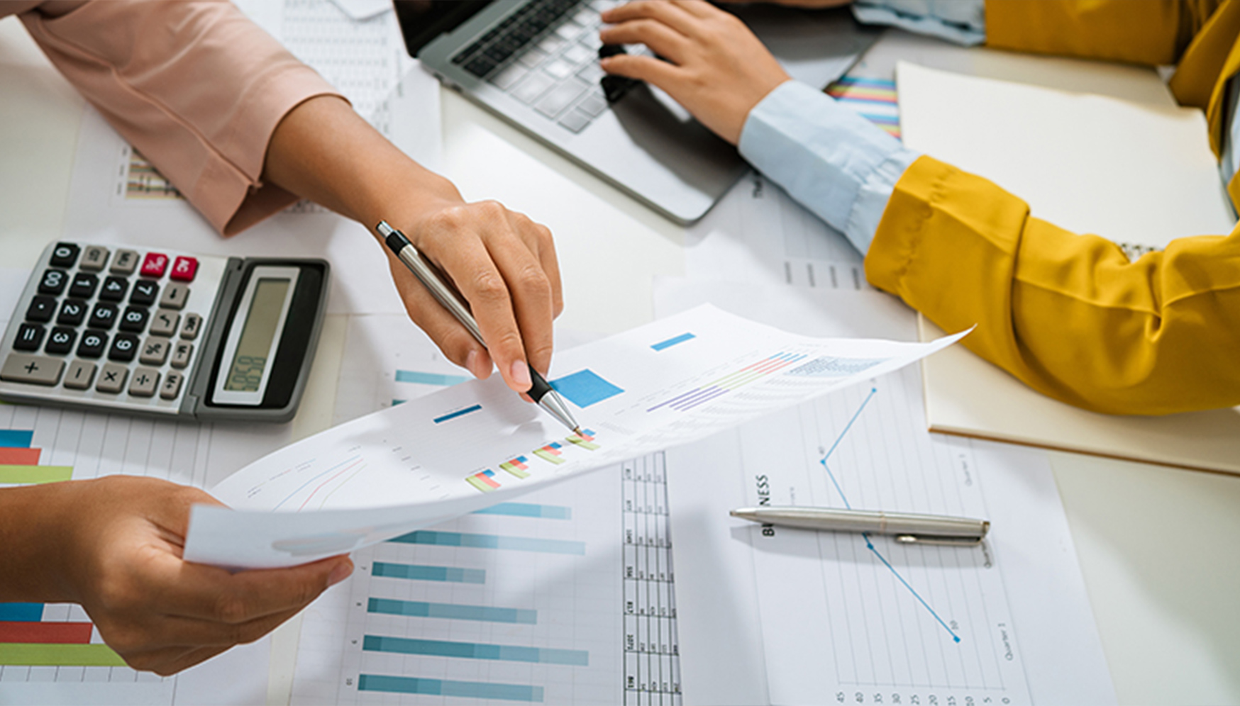a person holding a pen over a paper