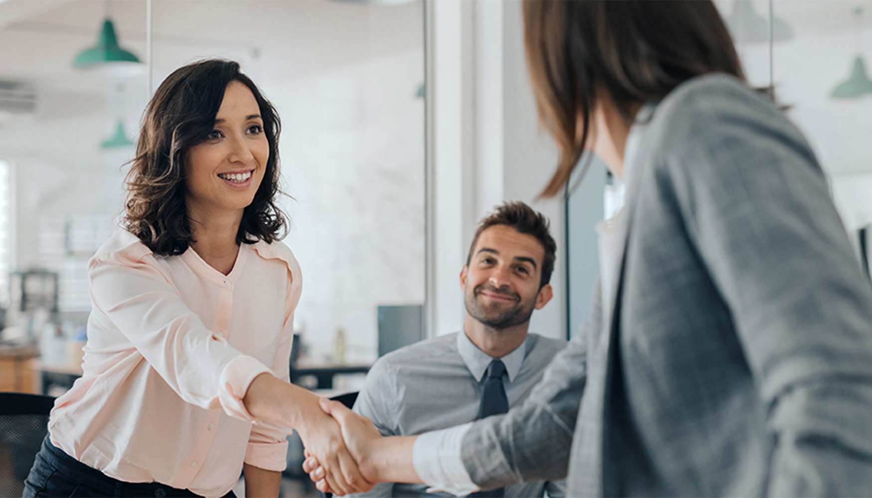a woman shaking hands with a man in a suit