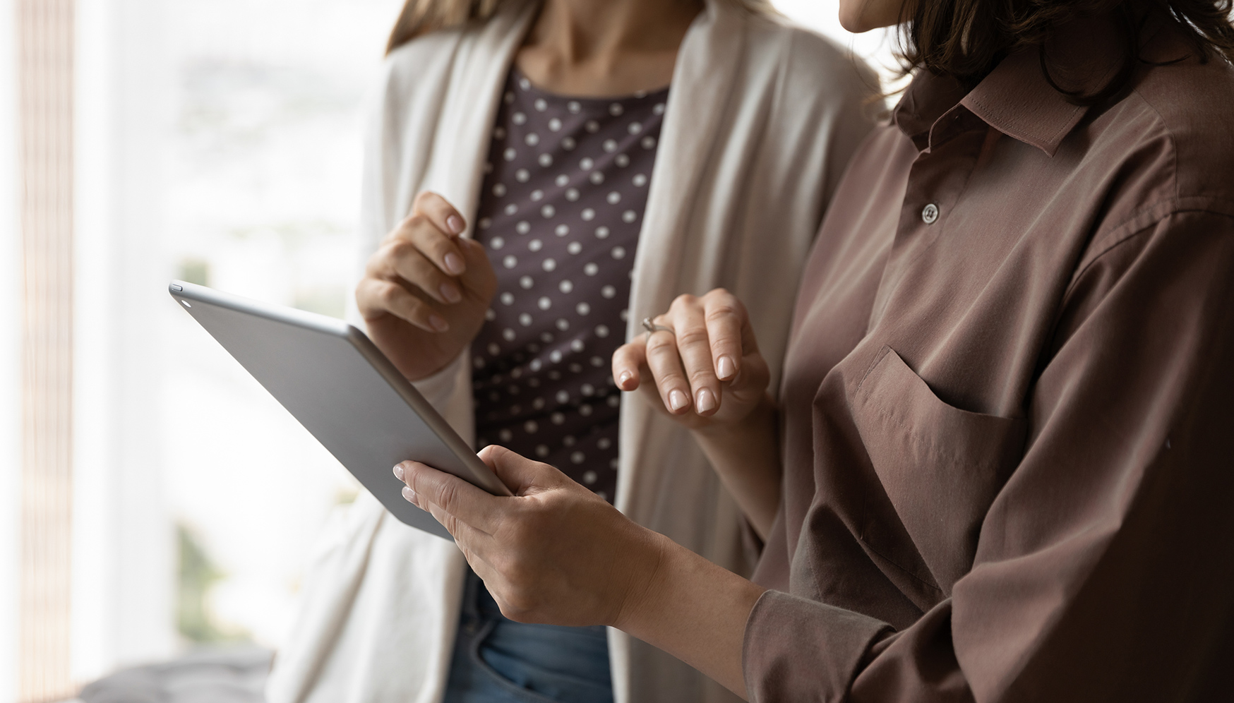 a woman holding a tablet and pointing at something
