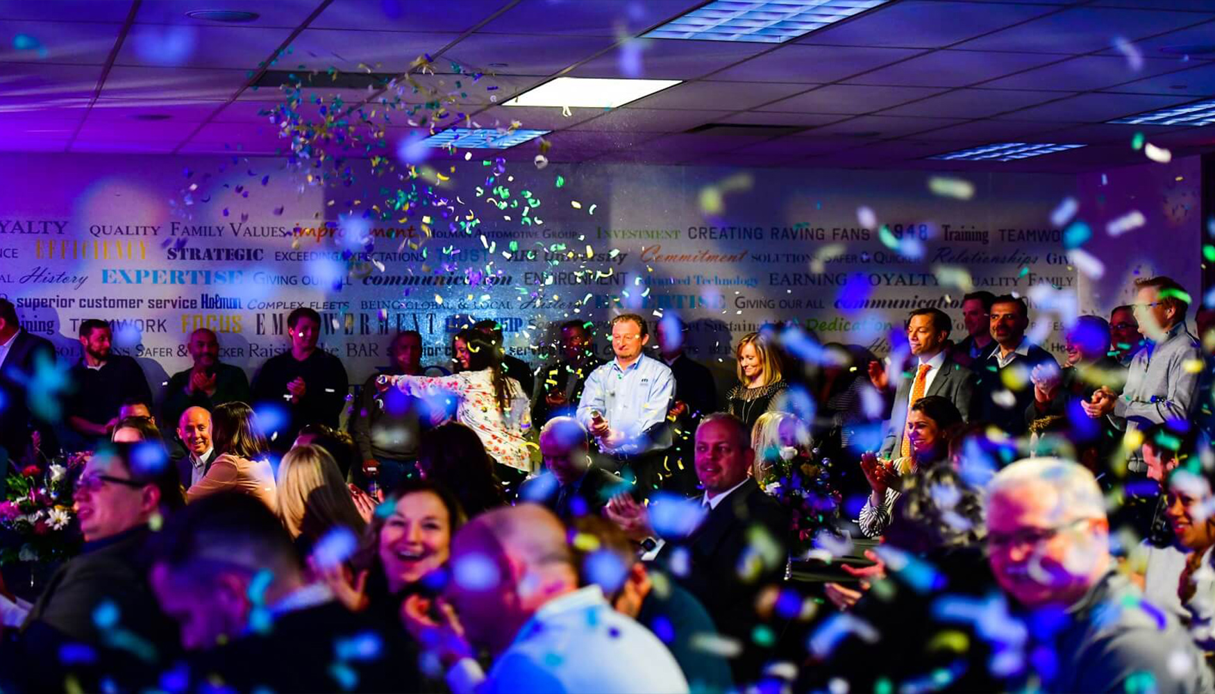 a group of people in a room with confetti