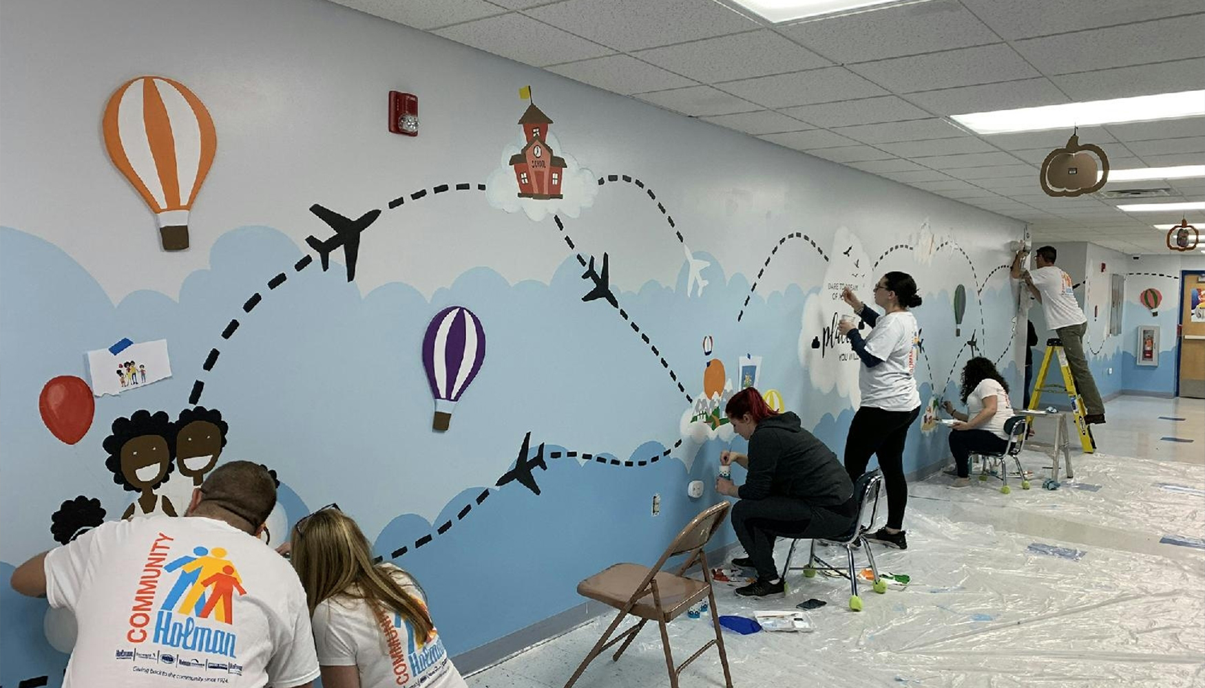 a group of people painting a wall