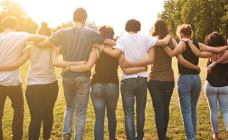 A group of people standing arm in arm