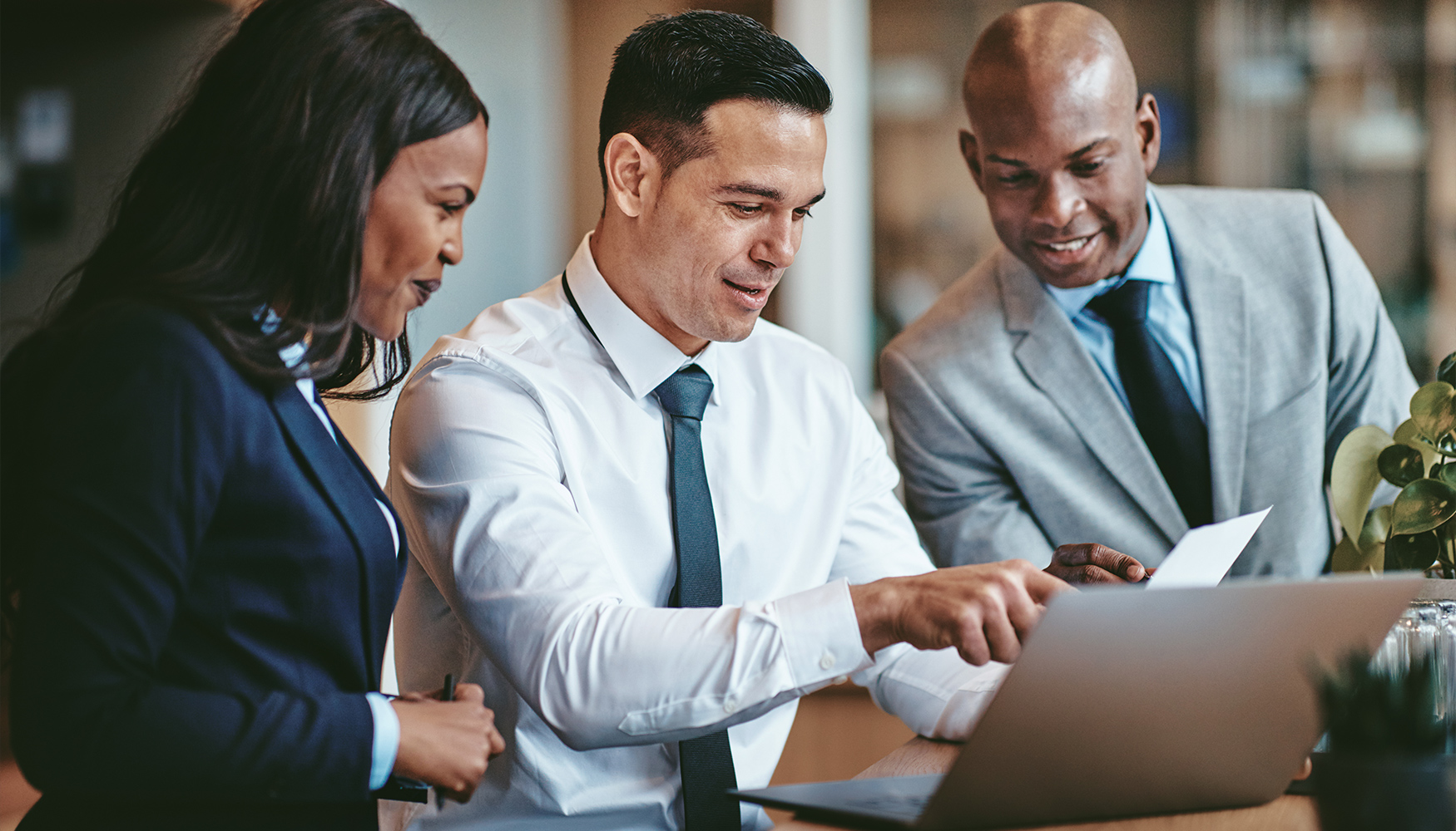 a group of people looking at a laptop